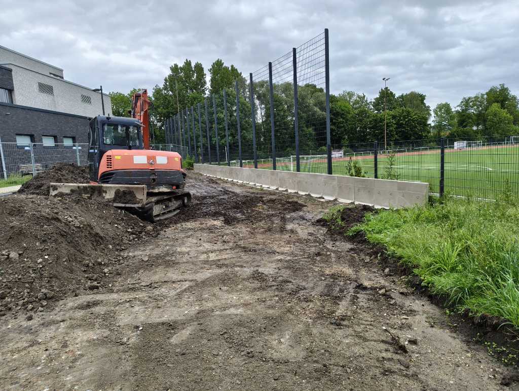 Bagger schiebt Erdreich auf dem Grundstück