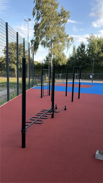 Calisthenics-Geräte auf dem fertigen roten Belag